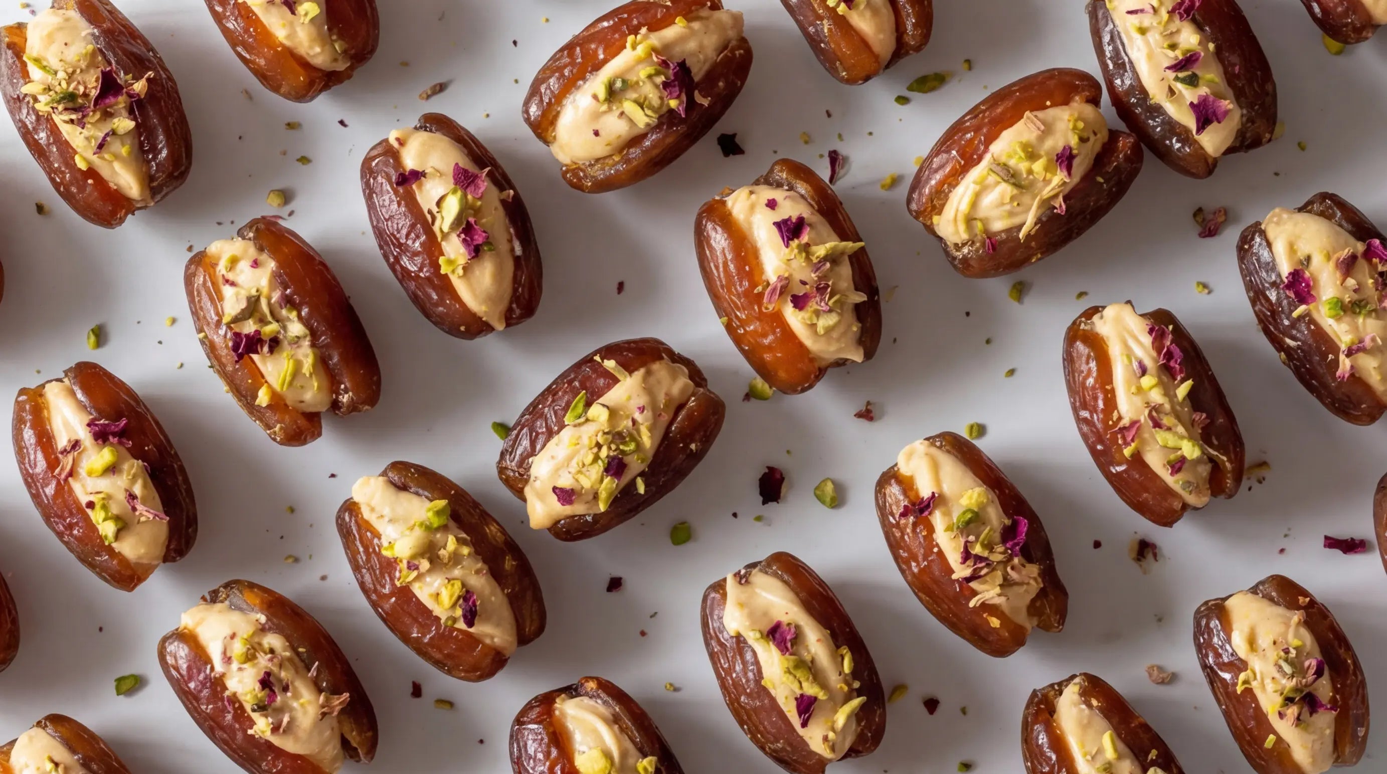 Date halves stuffed with a creamy filling on a light background